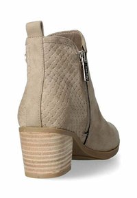 Botín de ante marrón con textura trenzada, cremallera lateral y un tacón apilado a rayas. La altura del tacón es moderada para mayor estabilidad.