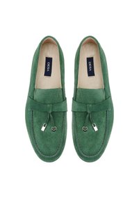 Green suede loafers with a traditional design, featuring a front bow tie, silver hardware accents, and a white rubber sole.