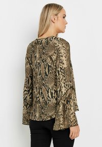 Beige- und schwarze Schlange-Print-Bluse mit ausgestellt geschnittenen Ärmeln, aus leichtem Stoff gefertigt, mit rundem Ausschnitt und lockerer Passform.