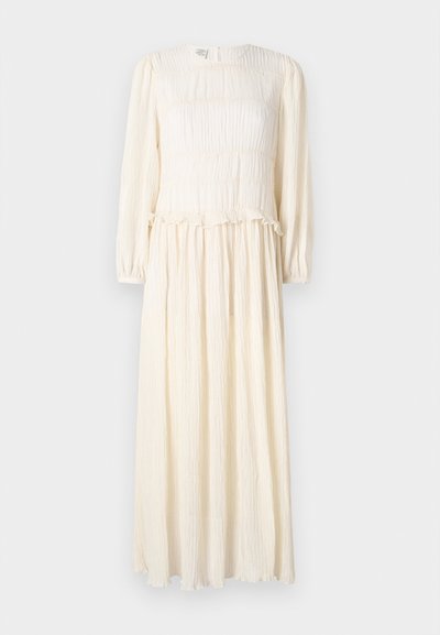 Long, cream-colored dress with long sleeves, textured fabric, smocked bodice, and ruffled hem. Lightweight and flowy design.