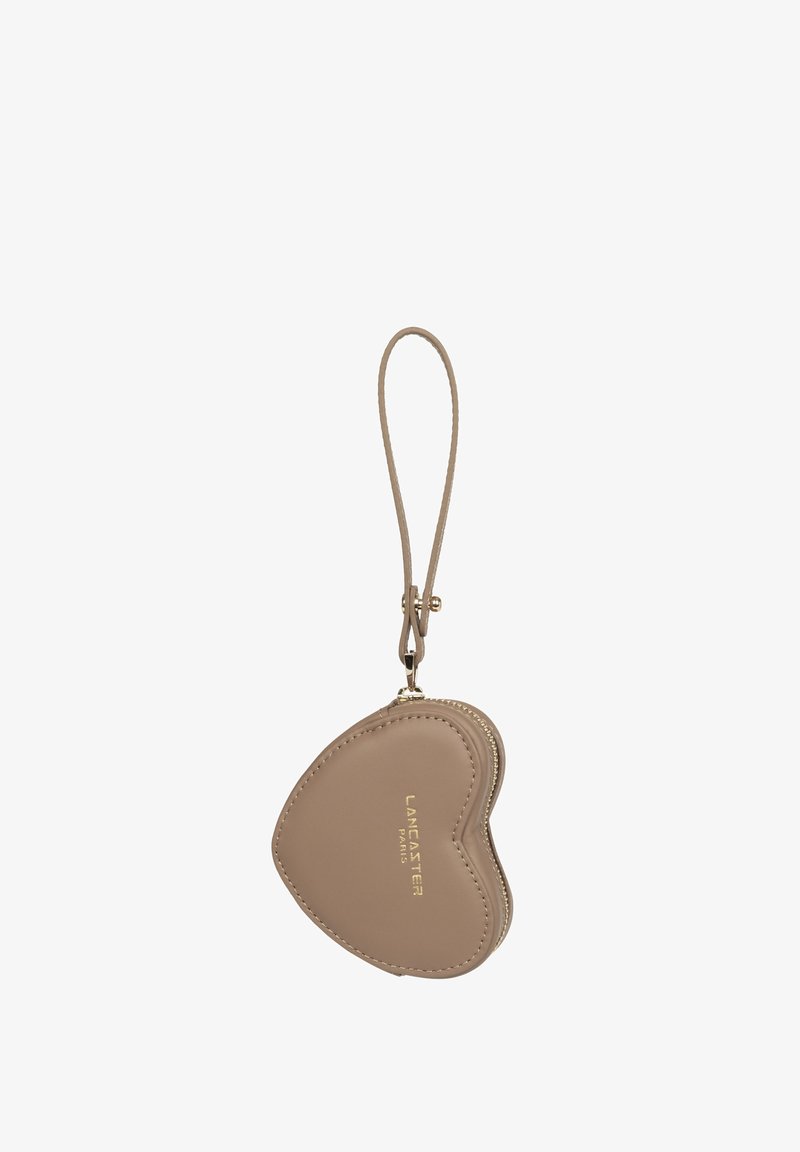 Petit porte-poignet taupe en forme de cœur avec fermeture éclair dorée et sangle, embossé du logo Lancaster Paris en lettres dorées.