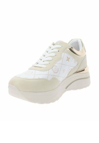 Zapatilla blanca y beige con una parte superior de cuero texturizado, cordones, acentos metálicos y una suela acolchada con un diseño estampado.