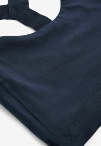 Top de algodón azul marino con escote redondeado, textura suave y tirantes de tela anchos con un sutil patrón de logo a lo largo del dobladillo.