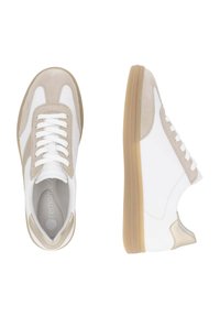 Baskets blanches et beiges en cuir et en daim, présentant un design à lacets, des semelles en caoutchouc, et une texture lisse avec un minimum de coutures.