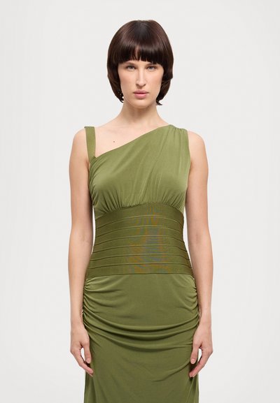 Robe verte asymétrique à une épaule avec un corsage froncé, une taille texturée et une jupe drapée. Tissu lisse avec une silhouette ajustée.