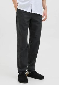 Pantalons noirs en tissu léger, présentant une coupe droite avec une texture lisse et des détails de couture minimaux.