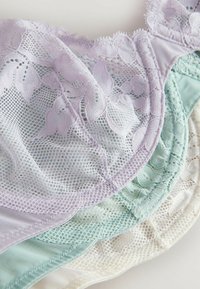 Kant beha's in pastelkleuren: lavendel, mintgroen en crème, met bloemmotieven en een zachte gaastextuur met golvende randen.