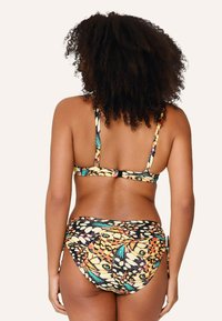 Conjunto de bikini con un estampado colorido de mariposas en amarillo, negro y azul verdoso. Cuenta con tirantes finos y un diseño de parte inferior de cintura alta.