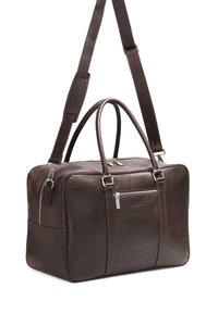 Borsa da viaggio in pelle marrone con doppie maniglie superiori, tracolla rimovibile, tasca frontale con zip e dettagli in metallo argentato. Texture liscia.