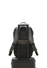 Sac à dos noir avec dos et bretelles rembourrés, attaché à une valise rigide grise. Design simple avec une texture lisse et sans motifs visibles.