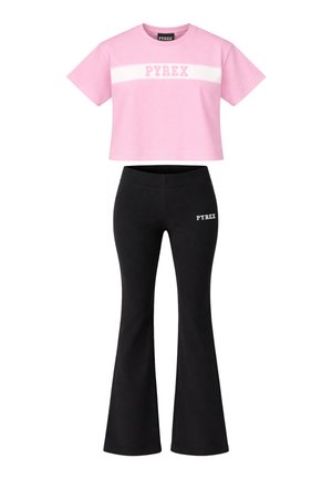 T-shirt corta rosa con striscia bianca e scritta "PYREX", abbinata a pantaloni neri svasati con piccolo logo bianco "PYREX" sulla coscia.