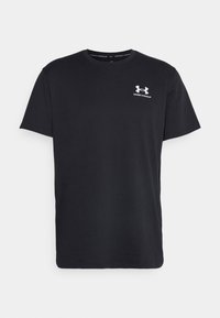 Črna bombažna majica s kratkimi rokavi, ki ima okroglo izrezano ovratnik in belo logo Under Armour na levi prsi. Gladka tekstura, standardna prileganje.