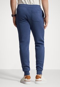 Herrars blåa sweatpants i en mjuk bomullsblandning, med justerbar midja, ribbade muddar och en enda bakficka.