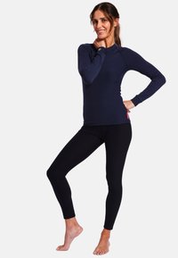 Sudadera de manga larga en color navy con cuello redondo y leggings negros elásticos, ambos hechos de una tela suave y ajustada. Sin patrones ni herrajes visibles.