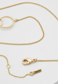 Collana dorata con design intrecciati di cerchi e catene. Include un gancio a incastro e un'etichetta con marchio. Finitura liscia e lucida.