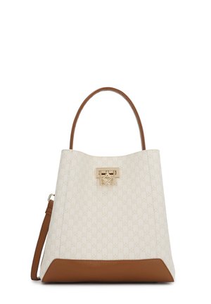 White patterned handbag with tan accents. Gold hardware closure in front. Sturdy brown handle and detachable shoulder strap.