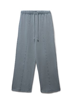 Pantalons larges gris clair avec une taille élastique, fermeture à lacets et détails de couture sur les coutures latérales. Tissu doux en mélange de coton.