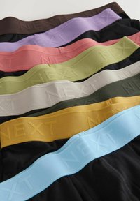 Hét pár férfi alsónemű csomag, fekete, barna, levendula, rózsaszín, zöld, bézs, olíva és sárga színekben, textúrázott rugalmas pántokkal, amelyeken a "NEXT" felirat szerepel.