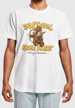 Ours en peluche marron avec des ailes et une auréole, tenant un arc et une flèche, portant un t-shirt blanc avec le texte « Ne pleure pas, n’oublie jamais, souviens-toi toujours ».