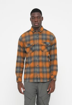 Flannel shirt in orange and gray plaid, featuring a button-up design, two chest pockets, and a curved hem. Made from textured fabric.