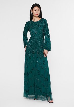 Vestido de noche de manga larga en verde esmeralda con intrincadas cuentas y patrones florales. Silueta fluida con una capa transparente.