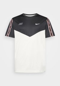 Black and white Nike short-sleeve shirt with chevron design, Nike logos on chest, and stripe with small swoosh logos on sleeves.