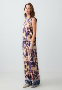 Geprinte mouwloze top en wijde broekset in blauw en beige met draaiende ontwerpen, met een gladde textuur en een relaxte pasvorm.