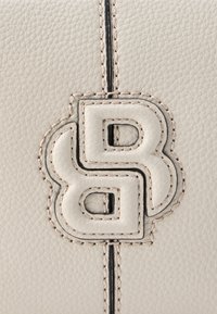 Svetlosivá kožená kabelka s textúrovaným materiálom, dekoratívnym prešívaním a výrazným logom s prepletenými písmenami v bielej farbe.