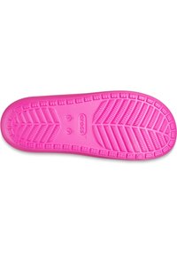Rosa gummisåle av en Crocs-sko med et teksturert mønster og hevet grep, inkludert numeriske størrelsesmarkeringer og merkevarelogo.