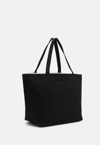Svart kanvastotepåse med två hållbara handtag, rektangulär form, slät textur och utan synlig hårdvara eller mönster.