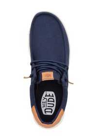 Scarpe slip-on in tela blu navy con un accento in pelle beige sul tallone. Presentano lacci rotondi e un rivestimento in tessuto nero con logo del marchio.