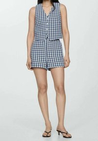 Gekämmtes zweiteiliges Outfit in Marineblau und Weiß. Ärmelloses Oberteil mit V-Ausschnitt und Knöpfen, kombiniert mit enganliegenden Shorts. Glatte Textur.