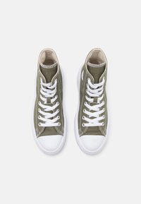 High-top sneakers in olive green canvas with white rubber soles, featuring white laces and stitching details, and a beige lining.
