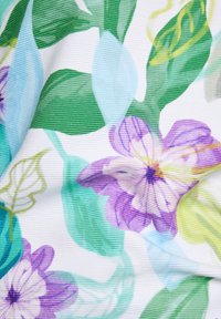 Floral patterned fabric featuring purple and green flowers with leaves on a white background; slightly textured surface with vertical lines.