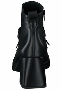 Botas negras de cuero hasta el tobillo con un tacón grueso, cierre de cremallera y acentos decorativos en los laterales. Textura suave con detalles de costura.