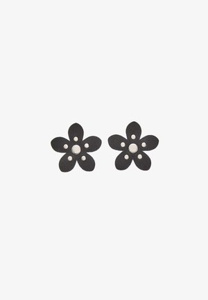 Orecchini in pelle nera a forma di fiore con cinque petali, una cupola centrale e quattro piccoli accenti metallici. Superficie testurizzata con finitura lucida.