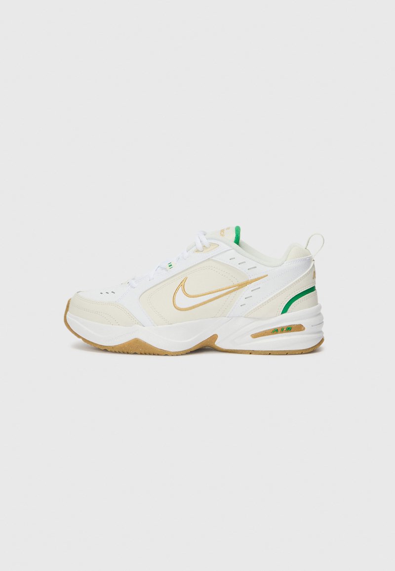 Fehér Nike sportcipők arany díszítéssel, texturált bőr és hálós felsőrésszel, zöld részletekkel és gumírozott talppal a tapadás érdekében.