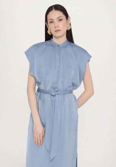 Ανοιχτό μπλε μεταξωτό φόρεμα με κοντά μανίκια, συγκεντρωμένος λαιμός, μπροστινό άνοιγμα, ζώνη με κόμπο και μπροστινές τσέπες. Απαλή υφή, μινιμαλιστικός σχεδιασμός.