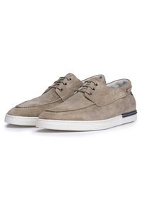 Scarpe in suede beige con punta cucita, lacci frontali e suola in gomma bianca. Presentano un interno grigio chiaro e un accento nero sul tallone.