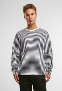 Langærmet T-shirt med rund hals i marineblå og hvide vandrette striber. Lavet af bomuld, med en glat tekstur og afslappet pasform.