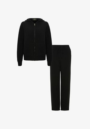 Schwarzer Hoodie mit Reißverschluss und zwei Fronttaschen, kombiniert mit passenden Jogginghosen mit Kordelzug. Hergestellt aus weichem Stoff mit gerippten Akzenten.