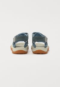 Blå och grå öppen-sandal med texturerad sula, justerbara remmar och stoppad fotbädd. Logotyp synlig på remmen.