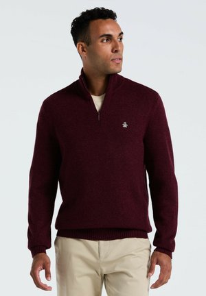 Bordeauxkleurige zip-neck trui gemaakt van textuurgebreide stof, met ribgebreide manchetten en zoom, en een klein logo op de linkerborst.