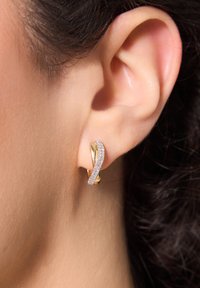 Złote i srebrne kolczyki o splocie, z paskiem błyszczących kamieni po jednej stronie. Gładkie wykończenie, elegancki kształt.