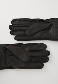 Black leather gloves feature a smooth texture, a fitted design with quilted accents, and individual finger compartments.