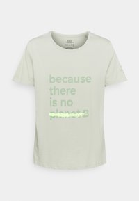 Camiseta de algodón verde claro con el texto "porque no hay un planeta B" en un verde más oscuro. Cuello redondo y mangas cortas.