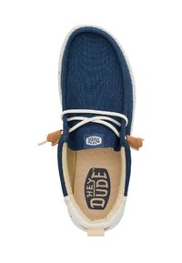 Scarpa slip-on in tela blu navy con suola bianca, dettagli in beige e lacci crema. Presenta una soletta imbottita con il logo "HEY DUDE".