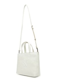 Borsa tote in pelle bianca Calvin Klein con manici superiori e tracolla rimovibile, logo goffrato, forma strutturata e texture liscia.