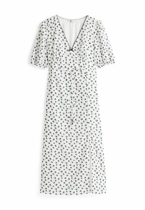 Biała sukienka z granatowym nadrukiem ptaków, dekolt w serek, krótkie bufiaste rękawy, taliowana, z bocznym rozcięciem. Lekki, zwiewny materiał.