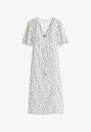 Biała sukienka z granatowym nadrukiem ptaków, dekolt w serek, krótkie bufiaste rękawy, taliowana, z bocznym rozcięciem. Lekki, zwiewny materiał.